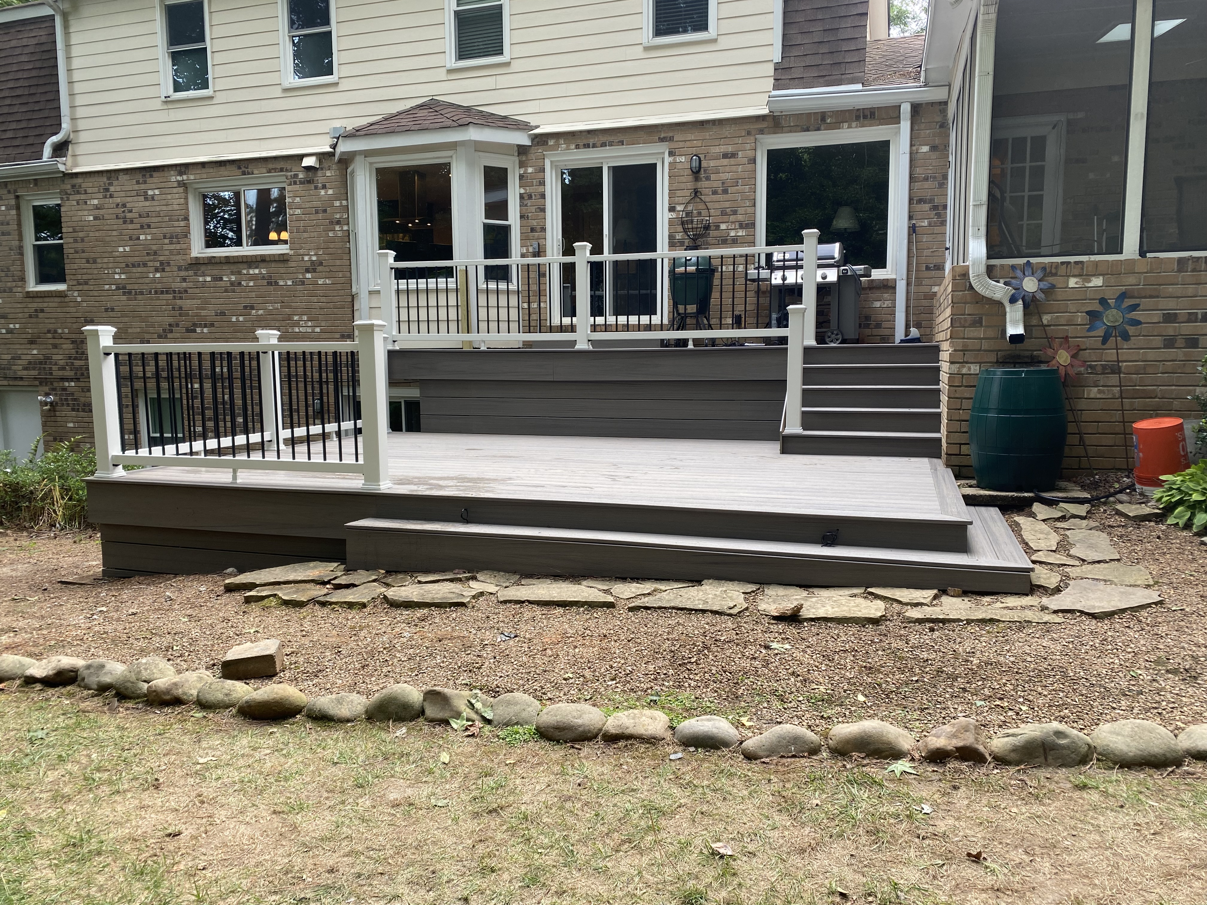 Multi-level backyard deck with white and black railing
